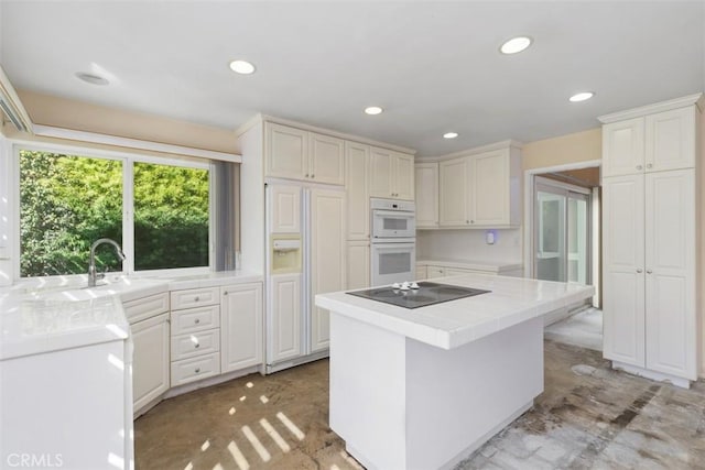 kitchen with double oven, white cabinetry, paneled built in fridge, and black electric cooktop