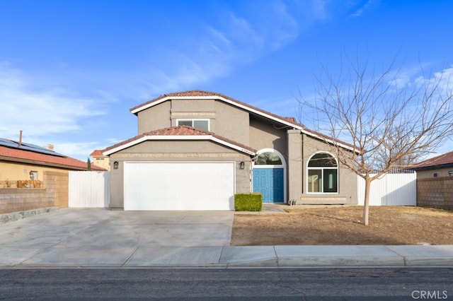 view of front facade featuring a tile roof, stucco siding, fence, a garage, and driveway