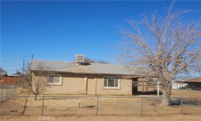 view of home's exterior featuring roof with shingles, central air condition unit, fence, and stucco siding