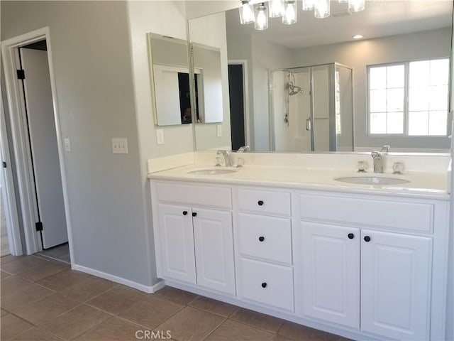 full bath with a stall shower, tile patterned floors, a sink, and double vanity