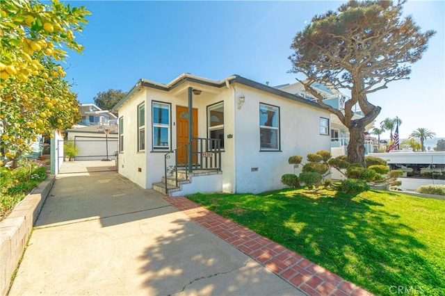 view of front of property with a front lawn, fence, and stucco siding