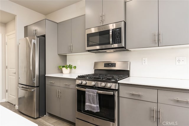 kitchen featuring gray cabinets, stainless steel appliances, and light countertops