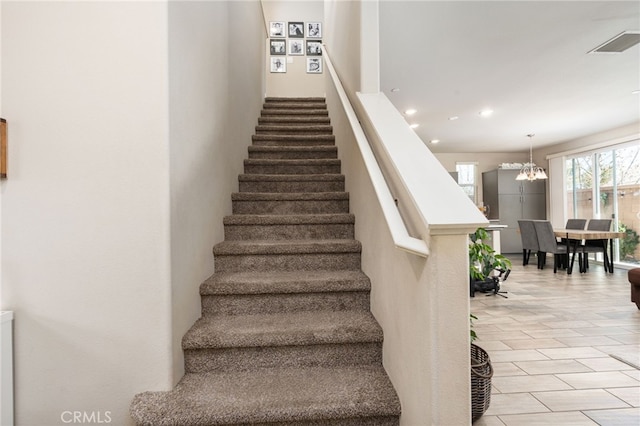 stairway featuring a chandelier, recessed lighting, and visible vents