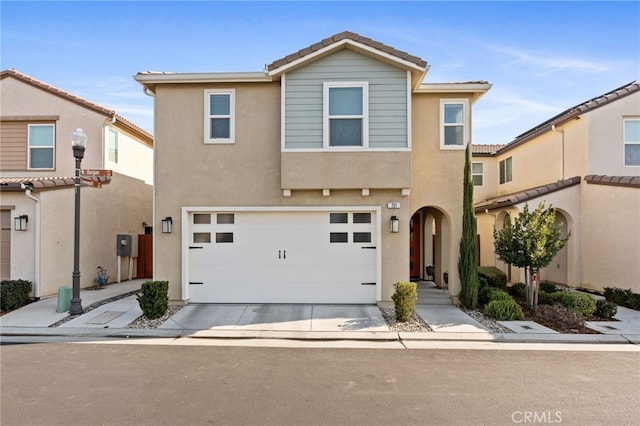 view of front of property with driveway, a garage, and stucco siding