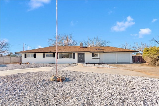 ranch-style house with a chimney, driveway, an attached garage, and fence