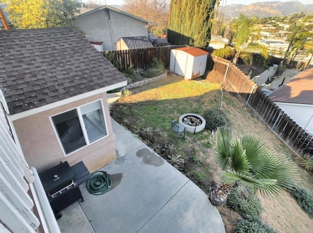 view of yard featuring a patio area, a shed, an outdoor structure, and a fenced backyard