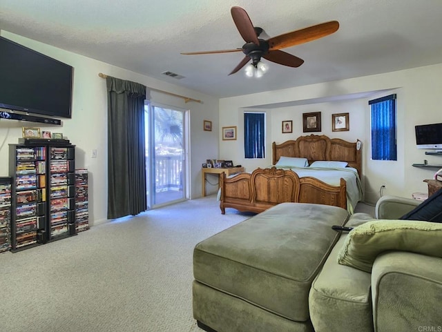 carpeted bedroom with a textured ceiling, access to outside, visible vents, and a ceiling fan