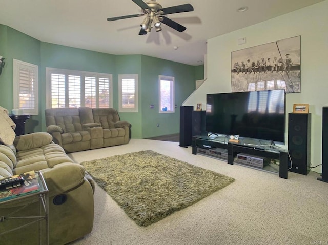 carpeted living area with a ceiling fan