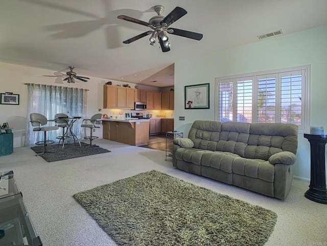 living area with ceiling fan and visible vents