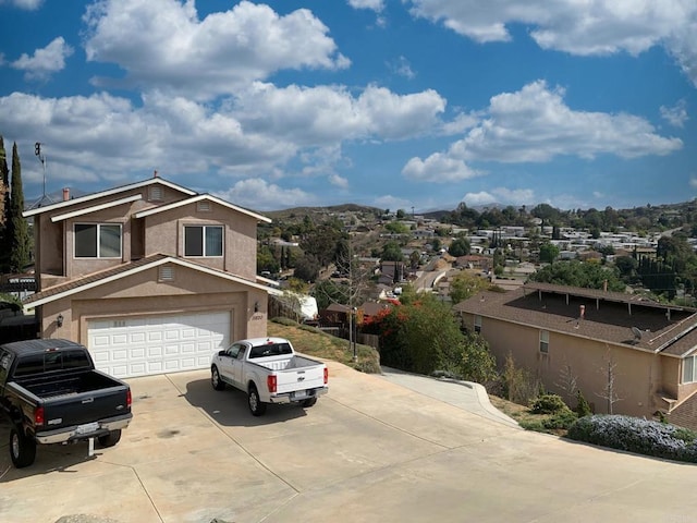 view of front of house featuring concrete driveway, an attached garage, and stucco siding