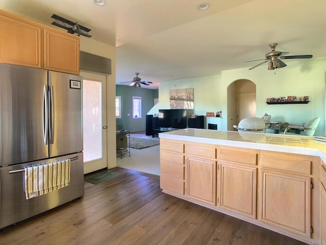 kitchen featuring dark wood-style floors, freestanding refrigerator, open floor plan, and light brown cabinetry