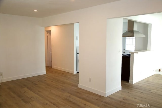 empty room with baseboards, wood finished floors, and recessed lighting