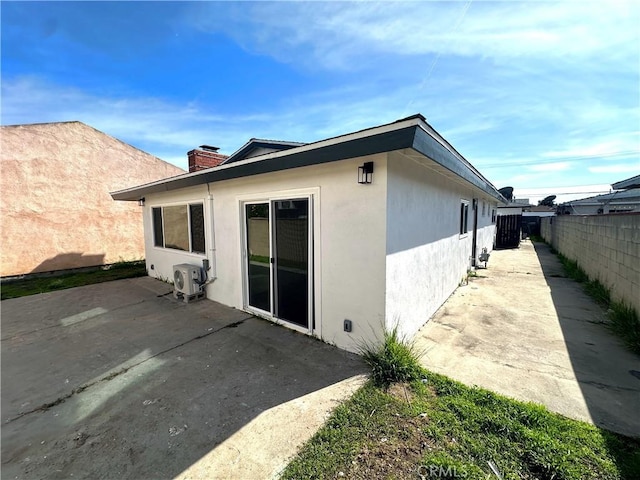 3659 W 110th St, Inglewood, CA 90303 - back of property with a patio area, stucco siding, a chimney, and fence