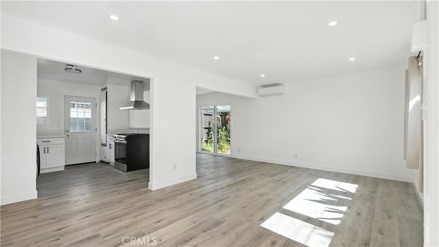 3659 W 110th St, Inglewood, CA 90303 - unfurnished living room with a wall unit AC, light wood finished floors, and recessed lighting