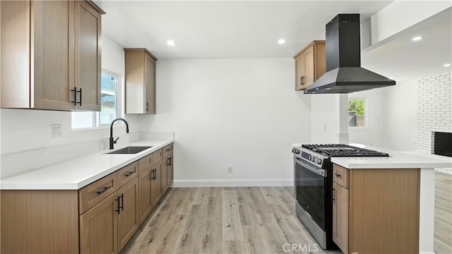 3659 W 110th St, Inglewood, CA 90303 - kitchen with gas range, wall chimney exhaust hood, light wood finished floors, light countertops, and recessed lighting