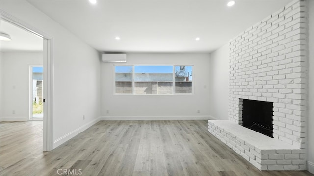 3659 W 110th St, Inglewood, CA 90303 - unfurnished living room featuring an AC wall unit, light wood-style flooring, a brick fireplace, plenty of natural light, and recessed lighting