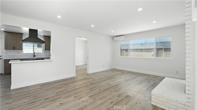 3659 W 110th St, Inglewood, CA 90303 - unfurnished living room featuring light wood-type flooring, recessed lighting, and an AC wall unit