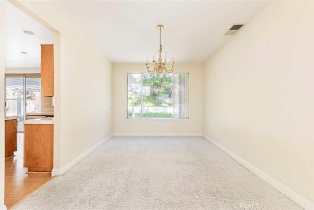 unfurnished room featuring visible vents, baseboards, and an inviting chandelier