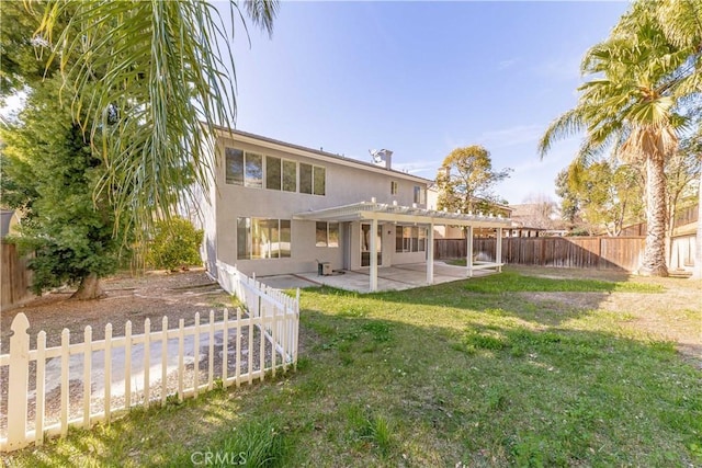 back of property with stucco siding, a fenced backyard, a lawn, and a patio