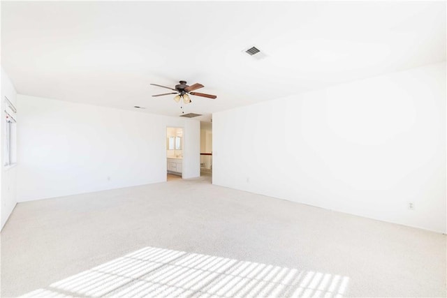 unfurnished room with ceiling fan, visible vents, and light colored carpet