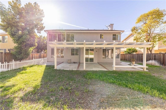 rear view of property with a yard, a fenced backyard, a patio, and stucco siding