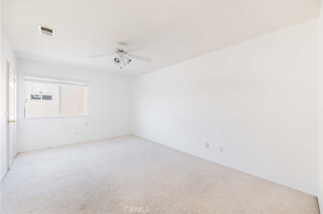 empty room featuring visible vents, a ceiling fan, and light colored carpet