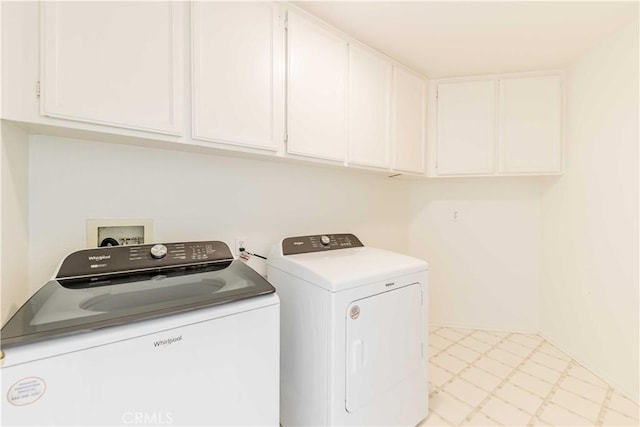 laundry area featuring cabinet space, washer and clothes dryer, and light floors