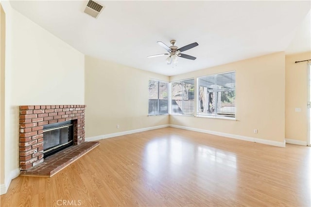 unfurnished living room with a fireplace, visible vents, a ceiling fan, light wood-type flooring, and baseboards