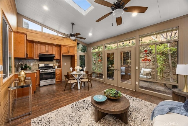 interior space featuring lofted ceiling with skylight, french doors, a sink, and a ceiling fan