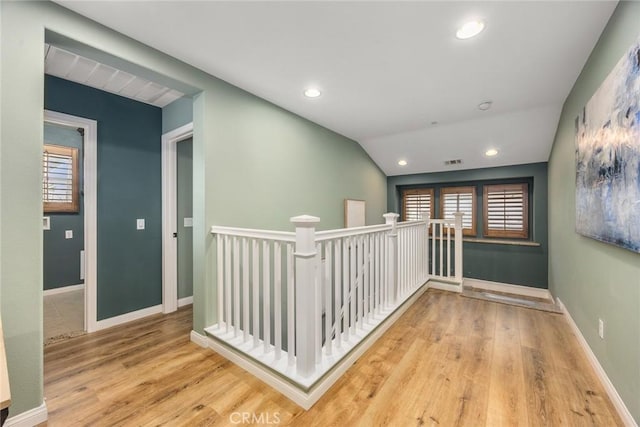 hallway featuring lofted ceiling, wood finished floors, an upstairs landing, and baseboards