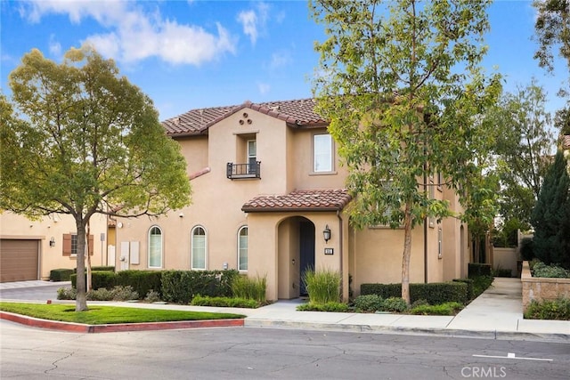 mediterranean / spanish-style home featuring a tiled roof and stucco siding