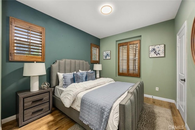 bedroom with baseboards and wood finished floors