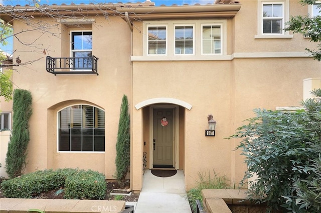 view of front facade featuring a balcony and stucco siding