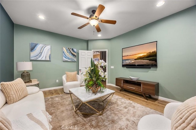 living room with baseboards, wood finished floors, and recessed lighting