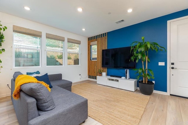 living room featuring baseboards, light wood-style flooring, visible vents, and recessed lighting