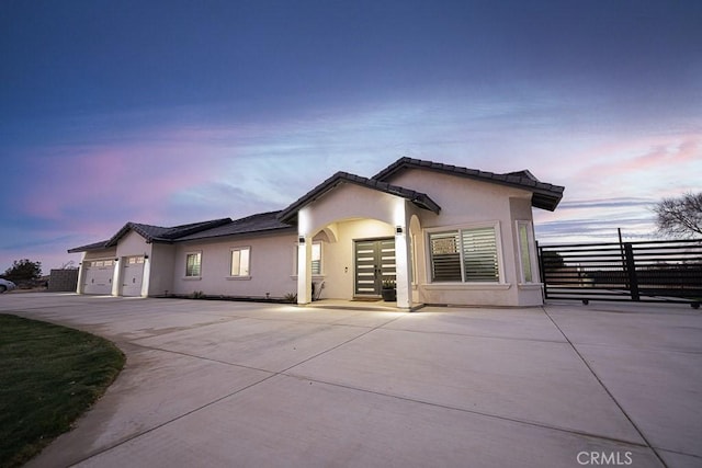 view of front of home featuring a garage, driveway, and stucco siding