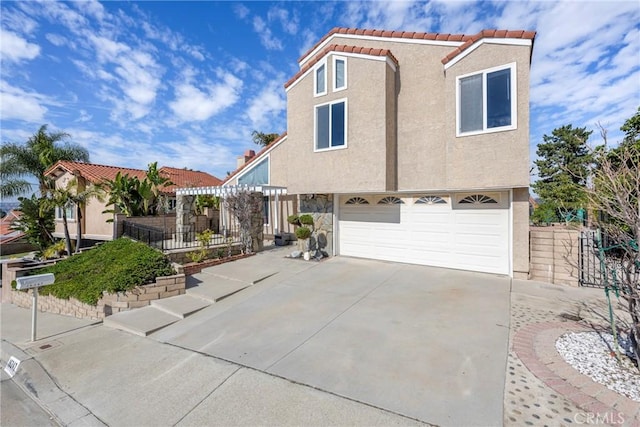 view of front of house with a garage, driveway, a tile roof, and stucco siding