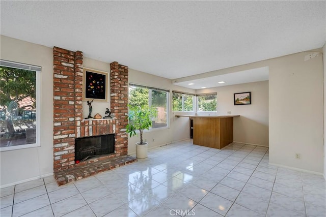 unfurnished living room featuring light tile patterned floors, a fireplace, baseboards, and a textured ceiling