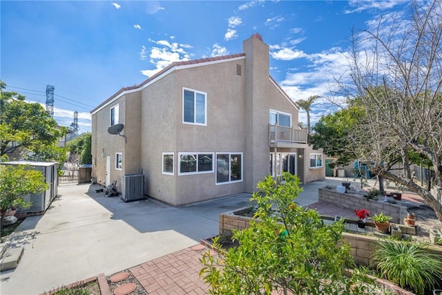 back of house with a patio, a balcony, and stucco siding