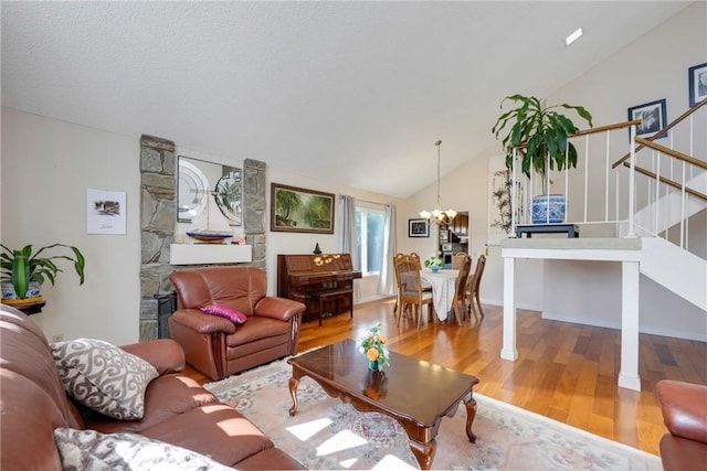 living room featuring stairs, wood finished floors, lofted ceiling, and a chandelier