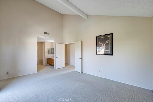 unfurnished bedroom with high vaulted ceiling, visible vents, beamed ceiling, and light colored carpet