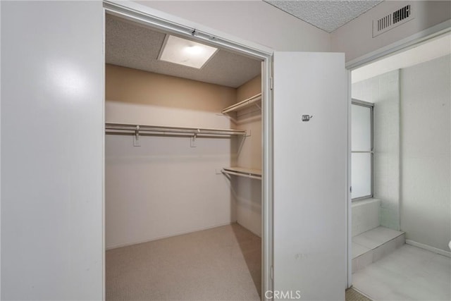 walk in closet with light carpet and visible vents