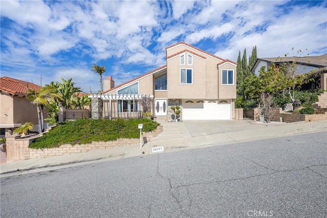 view of front of house featuring concrete driveway, an attached garage, and stucco siding