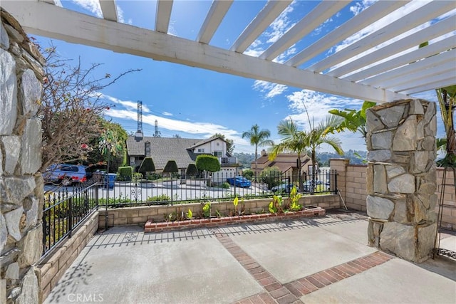 view of patio featuring a residential view, fence, and a pergola