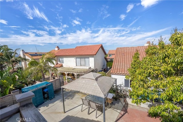 exterior space with a tile roof, a patio, and stucco siding