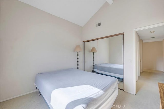 bedroom featuring a closet, visible vents, light carpet, and baseboards