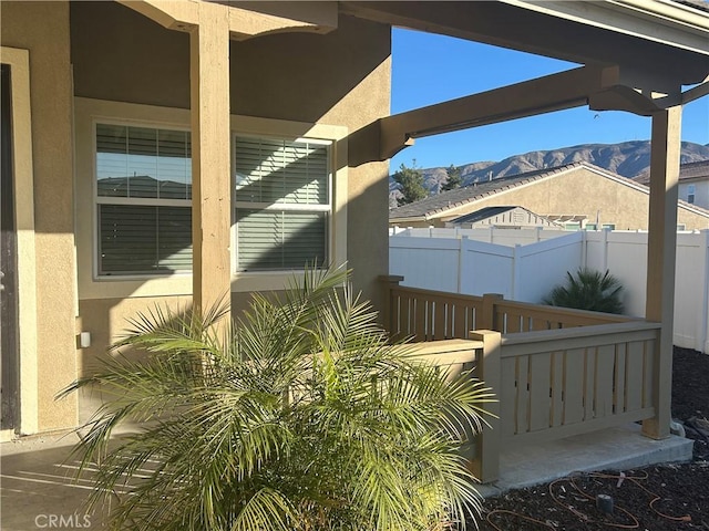 view of patio / terrace featuring fence and a mountain view