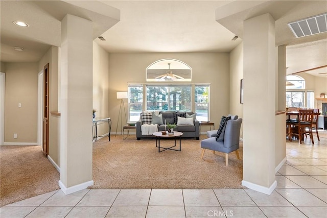 living area with light tile patterned floors, baseboards, visible vents, and light colored carpet