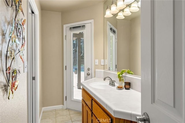 bathroom with vanity, baseboards, and tile patterned floors