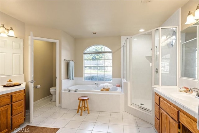 bathroom with a garden tub, toilet, vanity, a shower stall, and tile patterned floors